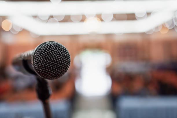 istock Microphone on abstract blurred conference hall prepare for speaker on stage in seminar room. lecture to audience university with bokeh background. Business meeting or education teaching image 1177834571