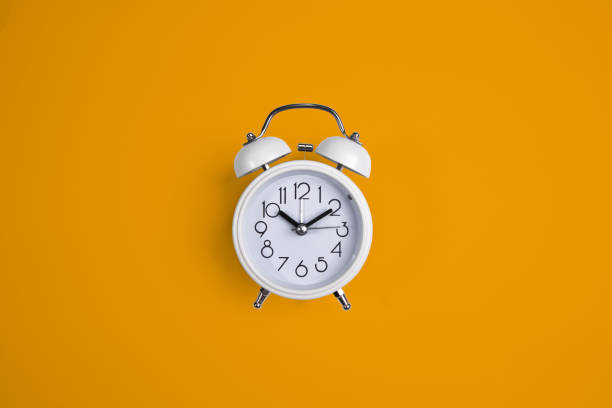 istock A white alarm clock on a yellow background. 1177834691