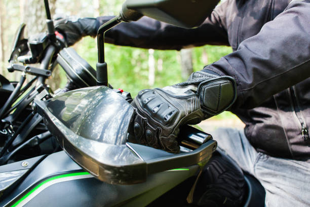 roda de direcção da motocicleta. opinião do close up das mãos nas luvas de punhos de preensão do motociclista da aceleração e do freio. homem unrecognizable no revestimento de couro preto no velomotor. - motorcycle mirror biker glove - fotografias e filmes do acervo