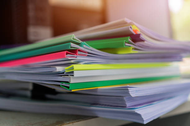 istock Piles unfinished documents reports files with overwork paper corner on teacher school desk office at university of Thailand. Stack of messy paperworks assessment legal folder at workplace concept 1177835133