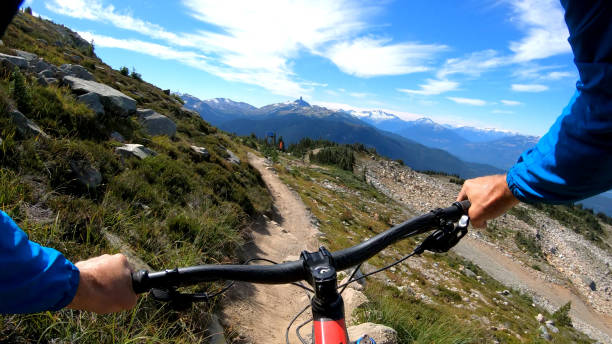 pov di mountain biker che scende sentiero in cima alla montagna - bikers point of view foto e immagini stock