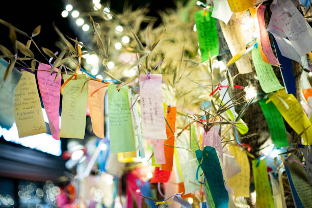Wishes written on Tanzaku, small pieces of paper, and hung on a Japanese wishing tree, located in the Little Tokyo section of Los Angeles, California, photographed at an outdoor mall at night. stock photo