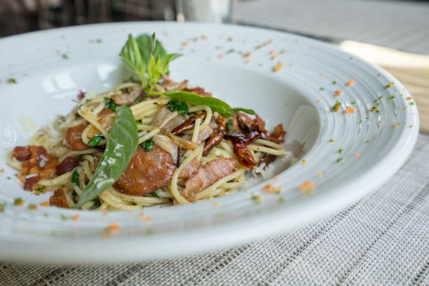 spaghetti with dry chili and beacon source-sage in white dish