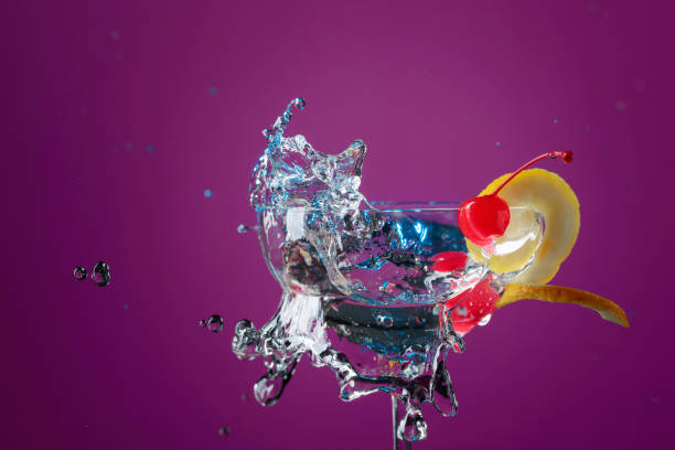 istock Ccktail in glass with splashes garnished with lemon and cherries. 1177843880