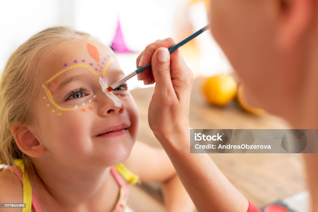 Joven Madre Pintando Hijas Cara Para La Fiesta De Halloween Halloween O Estilo De Vida Familiar De Carnaval Pintamiento Facial Y Vestirse Foto de stock y más banco de imágenes de Niño - Joven Madre Pintando Hijas Cara Para La Fiesta De Halloween Halloween O Estilo De Vida Familiar De Carnaval Pintamiento Facial Y Vestirse Foto de stock y más banco de imágenes de Niño -