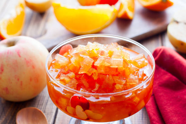 istock Fruit jam from apples and oranges in a glass vase on a wooden table, horizontal 1177845498