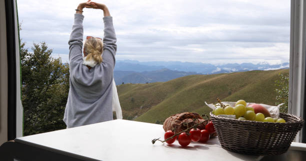 istock View past fruit to woman stretches outside motorhome 1177845514