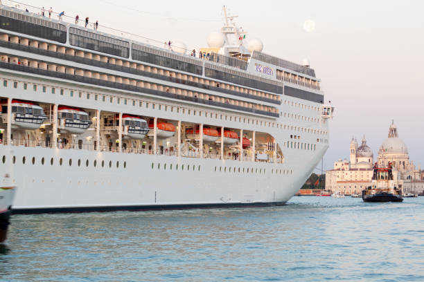 A huge cruise ship in St.Mark basic (San Marco basin) near Punta della Dogana in Venice lagoon entering Giudecca Canal. Seen from Riva San Biasio.