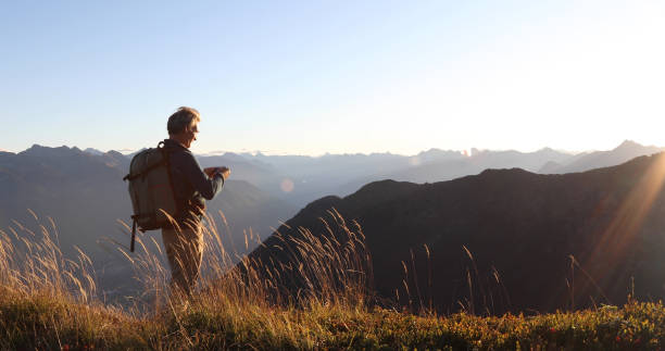 istock Man hikes along grassy mountain ridge at sunrise 1177845610