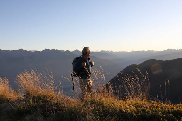 istock Man hikes along grassy mountain ridge at sunrise 1177845691