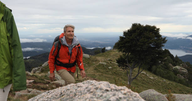istock Couple hike up grassy mountain ridge 1177846414