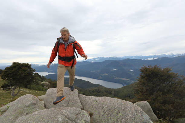 istock Man hikes along boulders on mountain ridge at sunrise 1177846579
