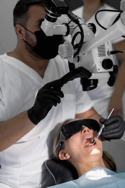 istock Dentist inspects a woman's oral cavity under a microscope 1177846792