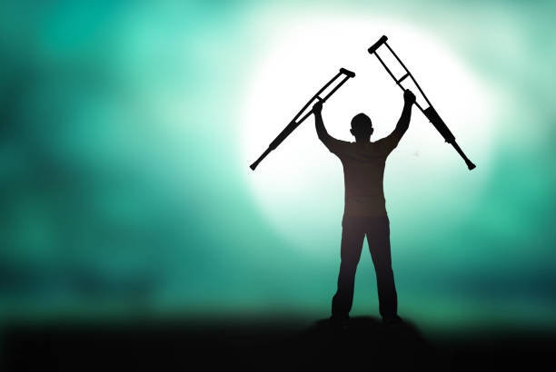 Silhouette human standing up and raising his crutches at full moon night background