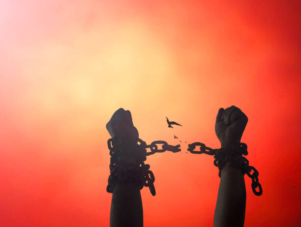 International day for the remembrance of the slave trade and its abolition concept Silhouette human hands raising and broken chains at night background hostage photos stock pictures, royalty-free photos & images