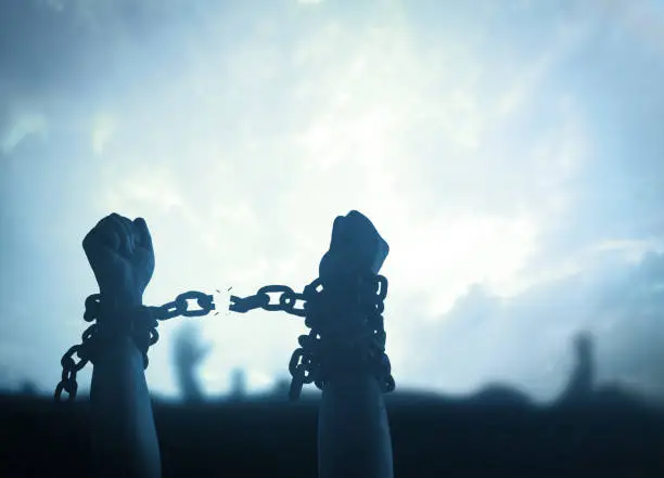 Silhouette human hands raising and broken chains at night background