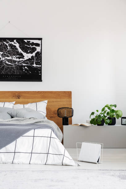 istock Copy space on white wall with black map in modern bedroom with king size bed with wooden headboard 1177849687