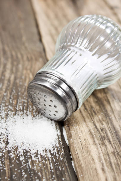 istock Salt and salt shaker on wooden background 1177851178