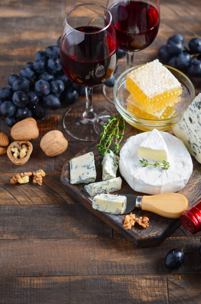 istock Cheese plate with grapes, honey, nuts and red wine on a wooden table. 1177851250