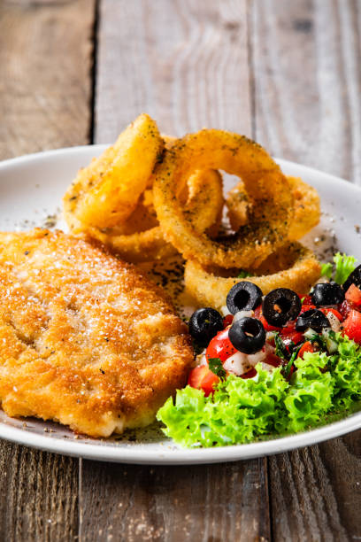 istock Fried pork chop with onion rings and vegetable salad on white plate 1177851452