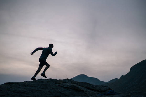 istock Cross country runner bounds up mountain 1177853076