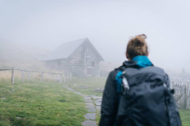 istock Hiker arrives at stone cabin in mist 1177853871