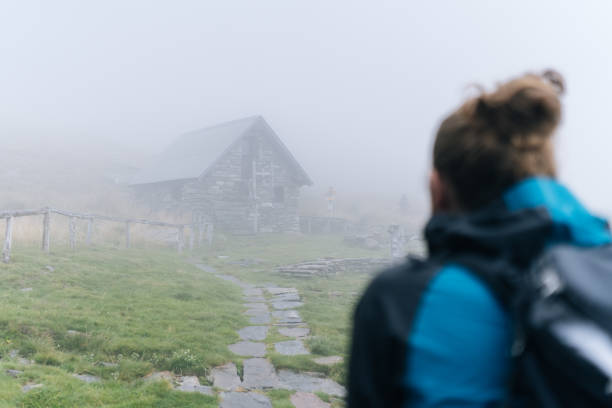 istock Hiker arrives at stone cabin in mist 1177853884