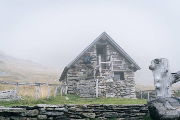 istock Man enjoys remote stone cabin in mountains 1177853904