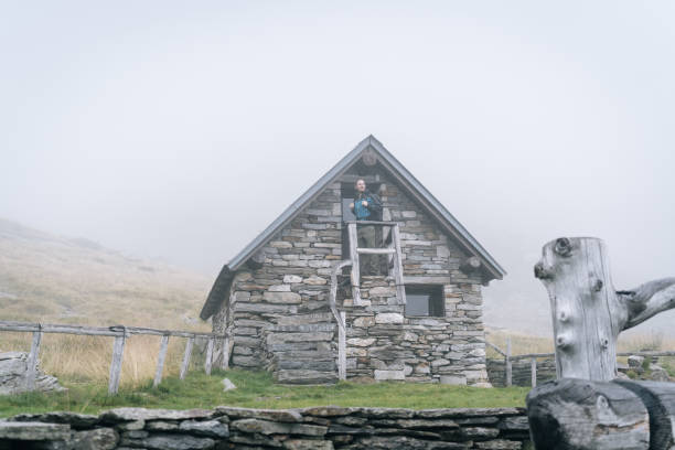 istock Man enjoys remote stone cabin in mountains 1177853913