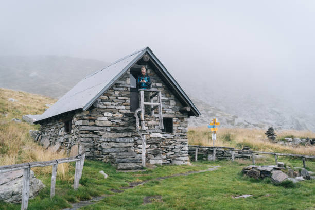 istock Man enjoys remote stone cabin in mountains 1177853938