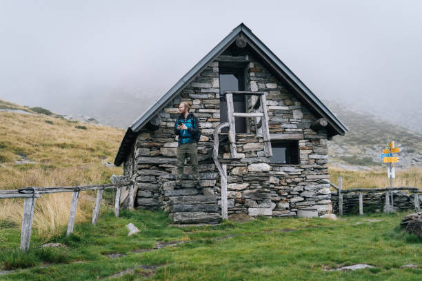 istock Man enjoys remote stone cabin in mountains 1177853945