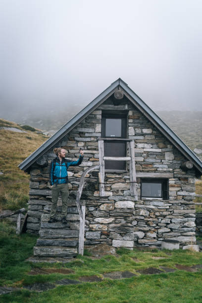 istock Man enjoys remote stone cabin in mountains 1177853948