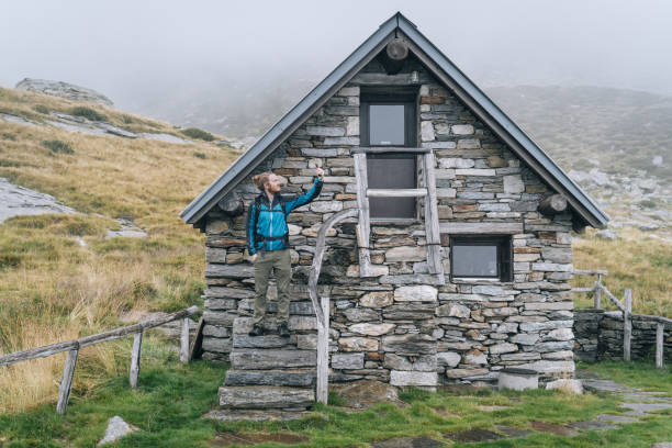 istock Man enjoys remote stone cabin in mountains 1177853978