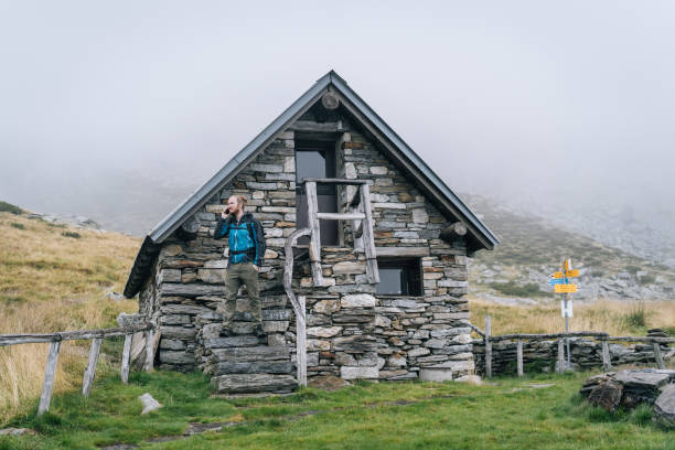 istock Man enjoys remote stone cabin in mountains 1177853980