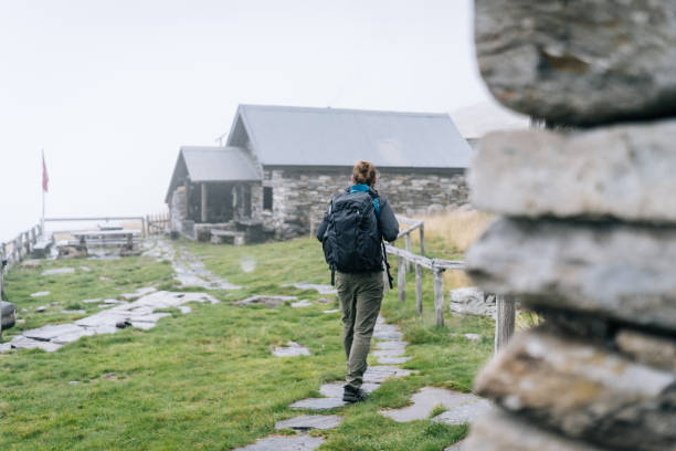 hiker leaves cabin in mountain meadow - switzerland cold green rock imagens e fotografias de stock