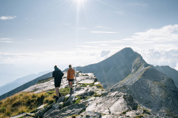istock Couple hike along a mountain ridge in the bright sun 1177854520
