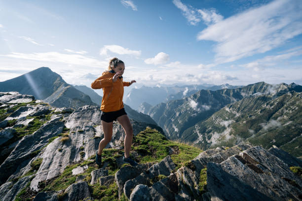 Young woman bounds along a mountain ridge