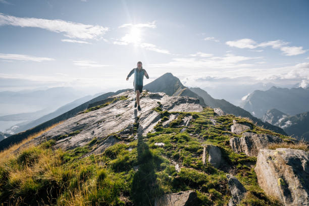 istock Trail runner bounds along a mountain ridge into the light 1177855328