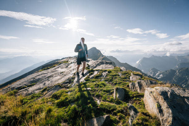istock Trail runner bounds along a mountain ridge into the light 1177855361