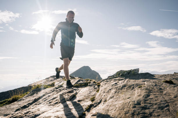 istock Trail runner bounds along a mountain ridge into the light 1177855367