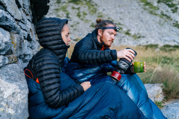 Couple cook on stove while rough camping