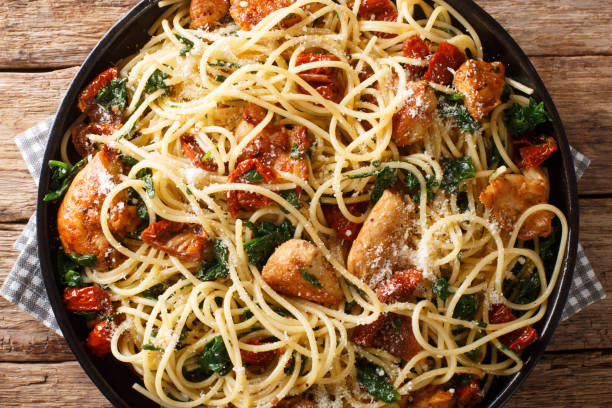 istock Pasta with dried tomatoes, chicken, parmesan and spinach close-up on a plate. Horizontal top view 1177860576