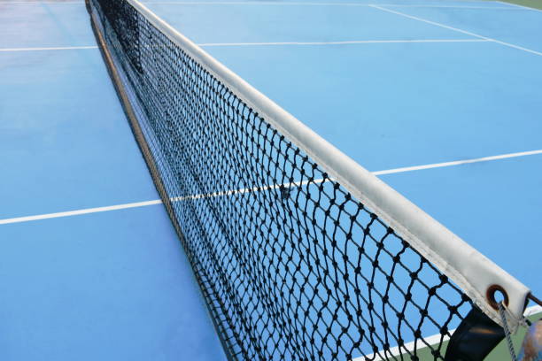 al netto del campo da tennis con linea di confine bianca sul pavimento blu - toughness surface level court tennis foto e immagini stock