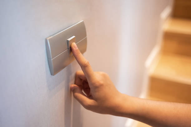 el primer plano del dedo se enciende o apaga el interruptor de luz en la casa. - pushing women wall people fotografías e imágenes de stock