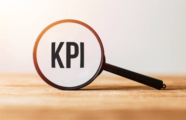 Magnifying glass with text KPI on wooden table. stock photo