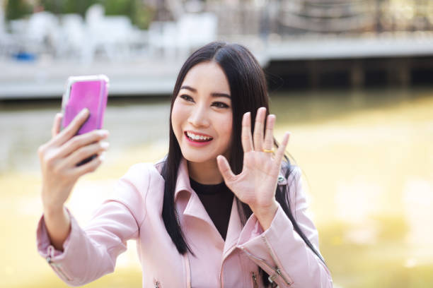 istock Thai woman waving at video chat 1177873600
