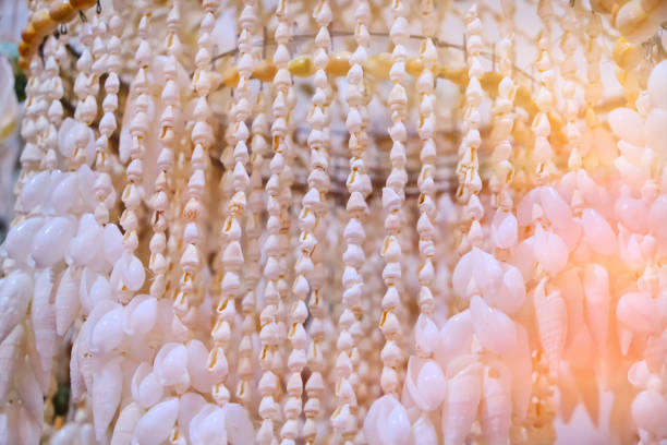 Colorful scallop seashells hanging in rows as decorative strings, creating a textured handmade coastal craft display