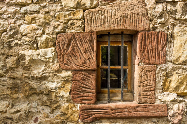Windows in an old stone wall in a house in Frome, Somerset. November 2024