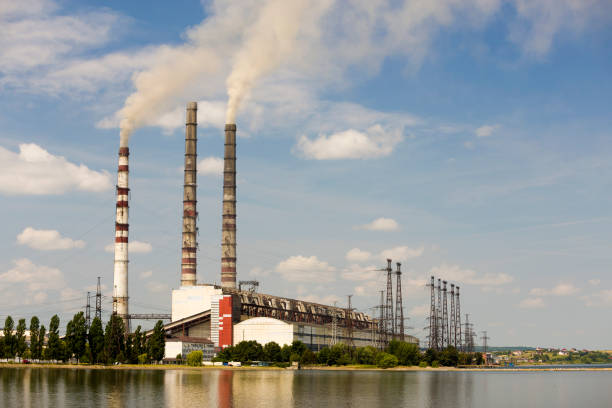 istock Thermal power station tall pipes with thick smoke reflected in lke water surface. Pollution of environment concept. 1177881083