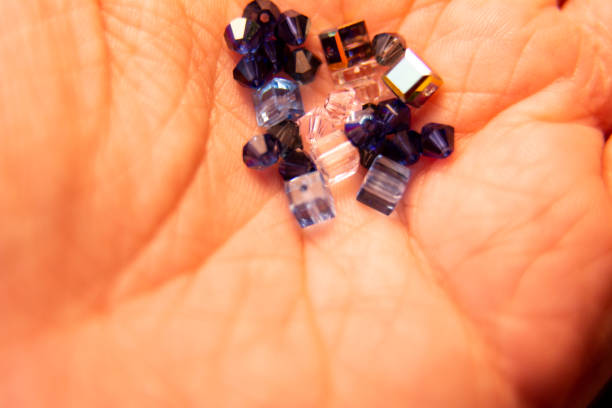 istock Tiny crystals being held in woman's hand, miniature crystal chips. Macro photo in natural lighting.Blurred photo. 1177883165